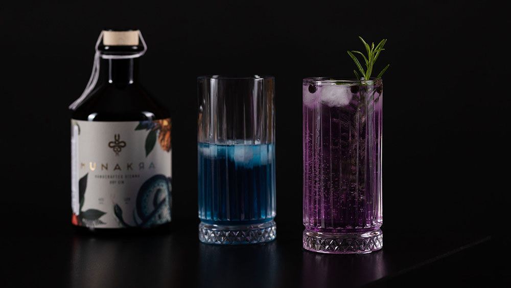 Munakra Gin – HANDCRAFTED VIENNA DRY GIN, eine Wacholderspirituose mit außergewöhnlicher, ausbalancierter Aromatik und floralen Zitrusnoten. Geheimnisvoll. Natürlich. Handgemacht. Natürlicher Farbwechsel auf Grudn mystischer Blume von blau auf vio. Florale Zitrusnoten